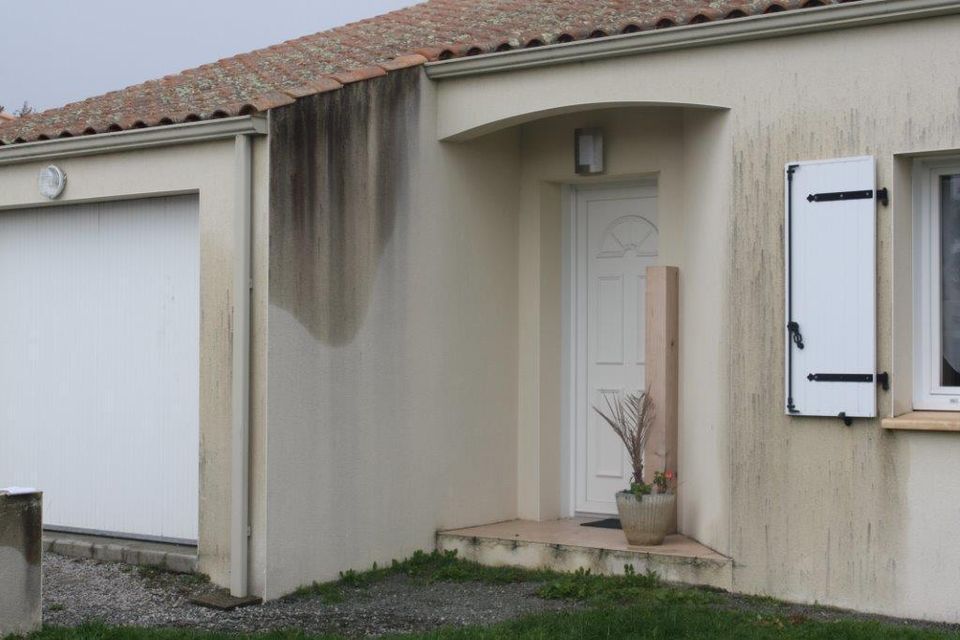 Façade de maison noircie autour des ouvertures à Aizenay, avant nettoyage